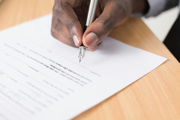 person writing on white paper