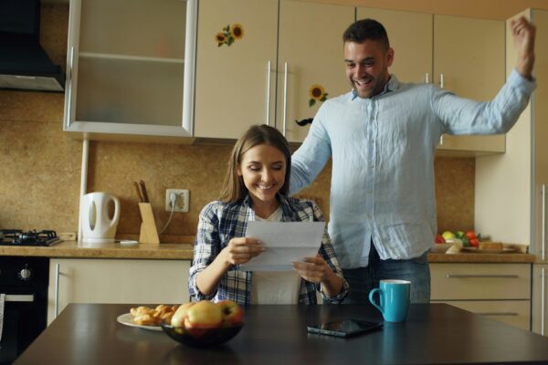 Couple celebrating good news in the kitchen.