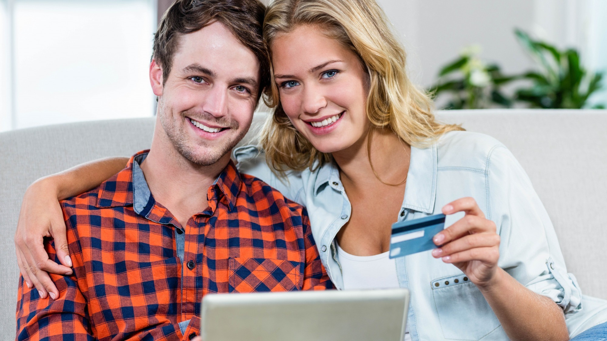 Couple paying with credit card on the couch