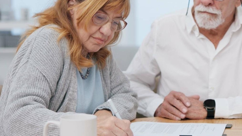 Senior couple insurance and contract with financial advisor and retirement plan to sign Document pension and business analyst with information and paperwork in office for signature of will