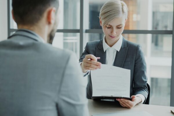 Woman in suit shows document to man