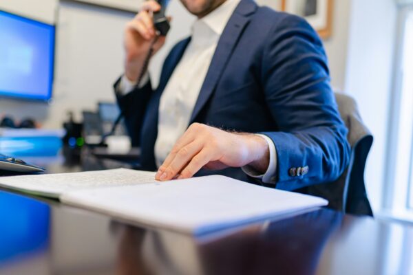 a man sitting at a desk writing on a piece of paper