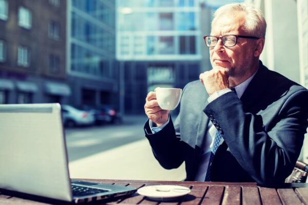 senior businessman with laptop drinking coffee