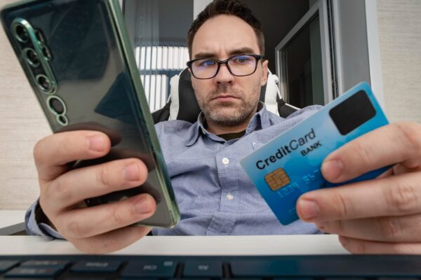 Businessman hand holding credit card to online shopping from home with laptop payment ecommerce internet banking man enters the card details on the website