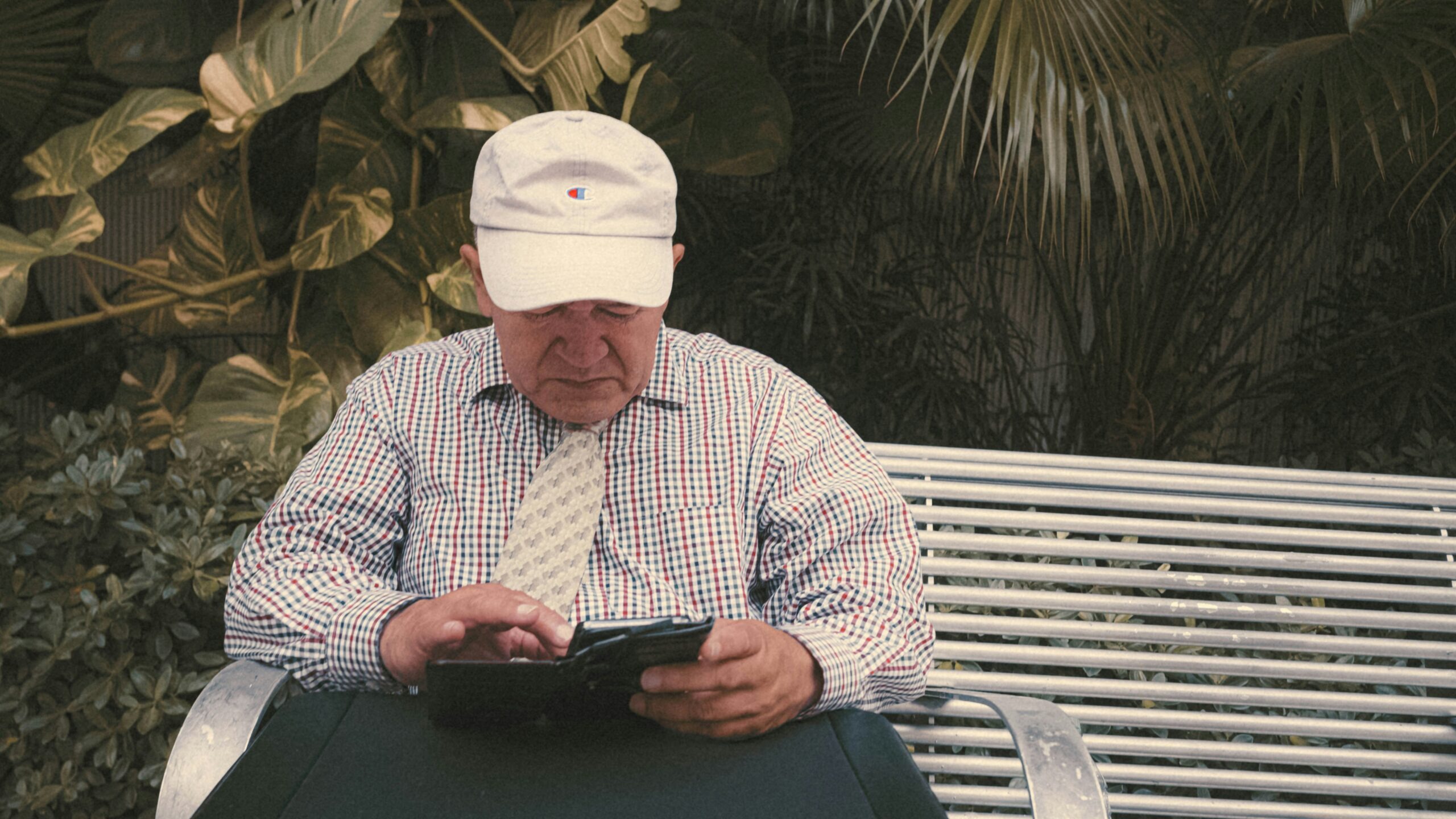 a man sitting on a bench looking at his cell phone