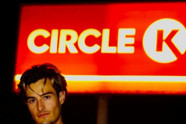 A man standing in front of a circle k sign
