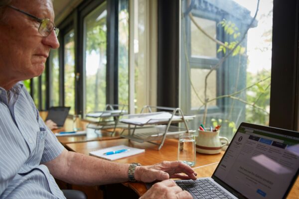 a man sitting at a table using a laptop computer