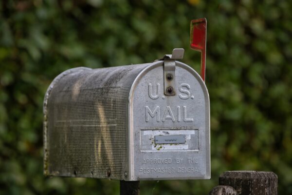 A u.s. mail mailbox stands outdoors.