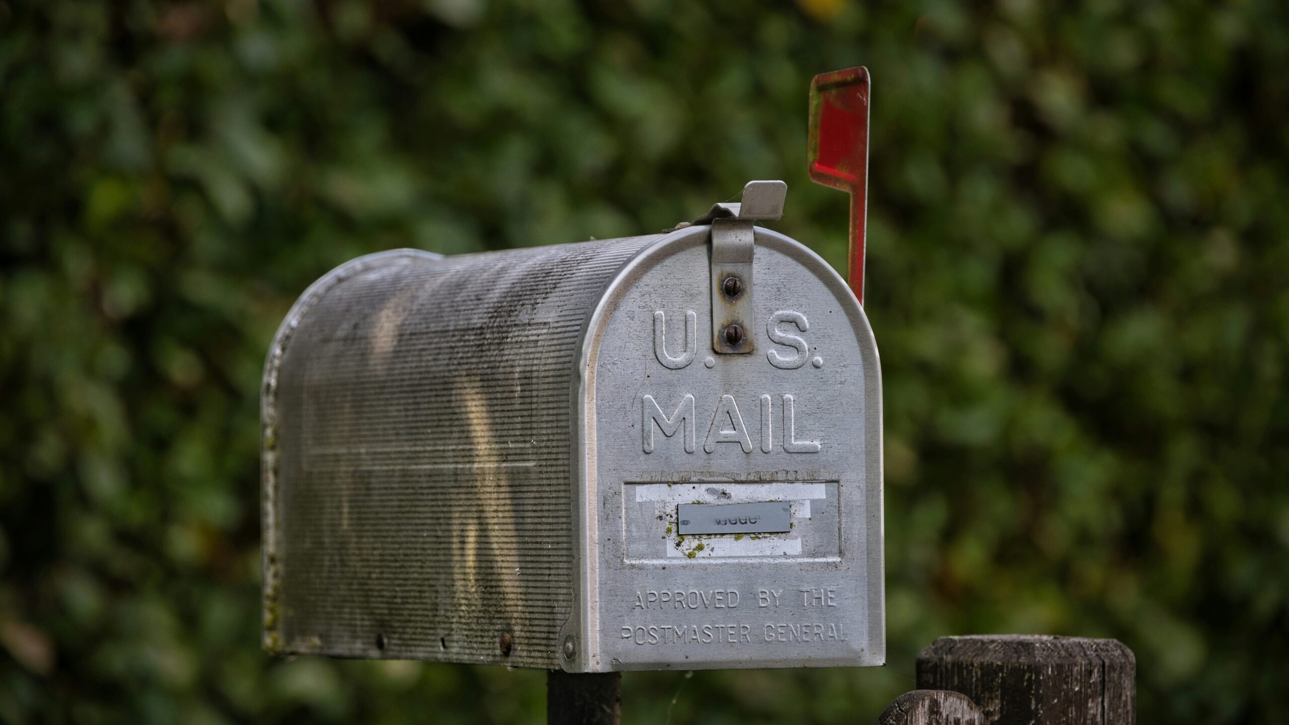A u.s. mail mailbox stands outdoors.