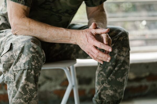 Close-up of a military veteran's hands in a therapy session, emphasizing mental health support.