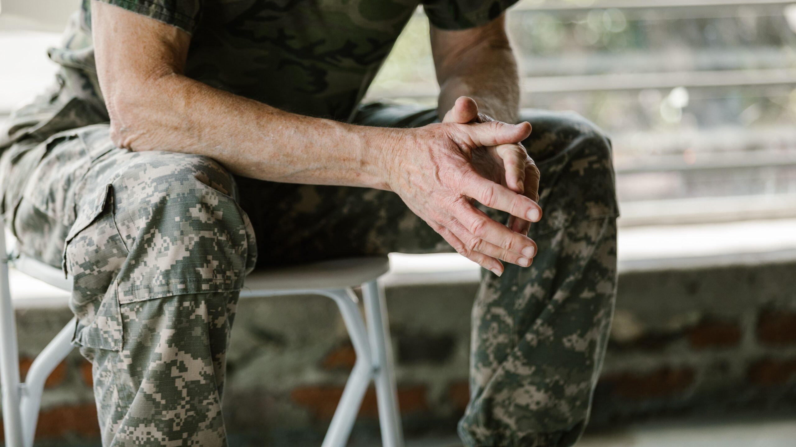 Close-up of a military veteran's hands in a therapy session, emphasizing mental health support.