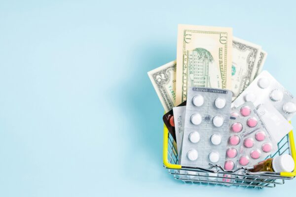 a shopping cart filled with pills and money