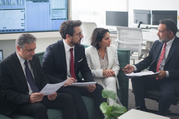 Group of business professionals discussing financial strategies in a modern office setting.