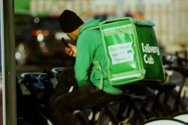 A man sitting on a bike with a bag on his back