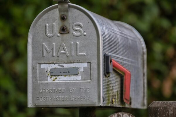 A weathered u.s. mailbox with a red flag.