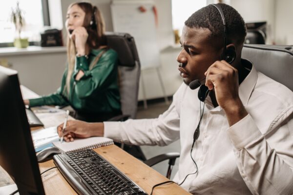 A focused team of customer service representatives working on computers and answering calls in an office