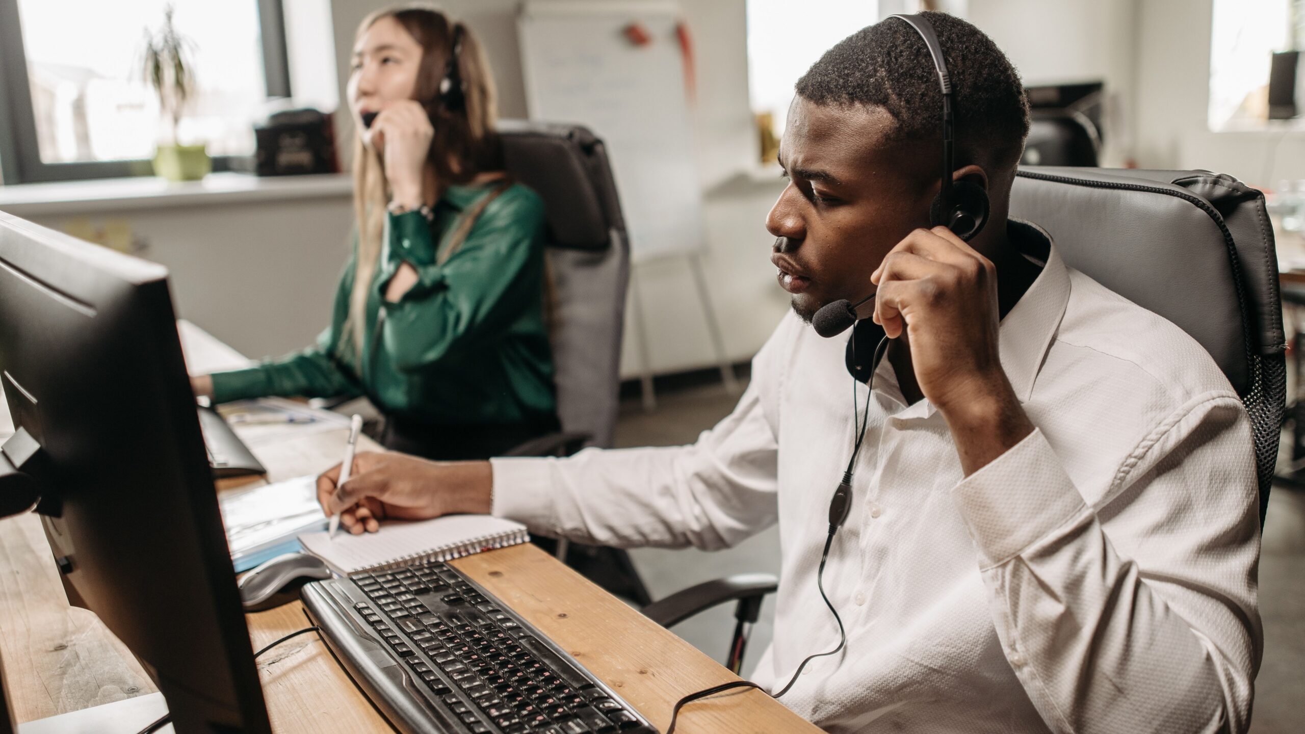 A focused team of customer service representatives working on computers and answering calls in an office