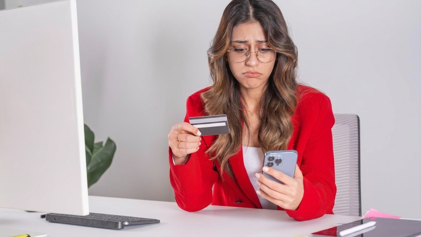 Business woman holding credit card and mobile phone Making payment sitting desk at office