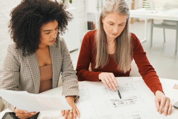Business women blueprint and home design with floor plan and teamwork for construction meeting Management collaboration and paperwork for house layout and renovation drawing in creative office