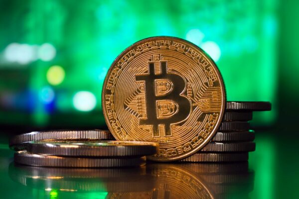 a bit coin sitting on top of a stack of coins