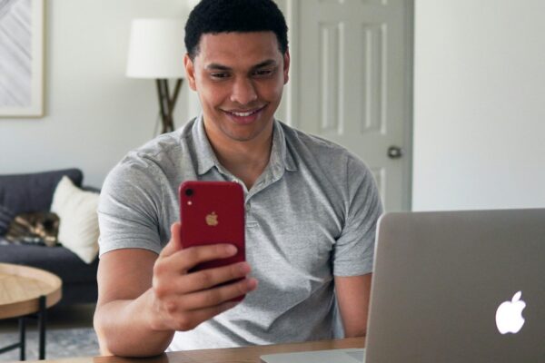 man in gray crew neck t-shirt holding red iphone case