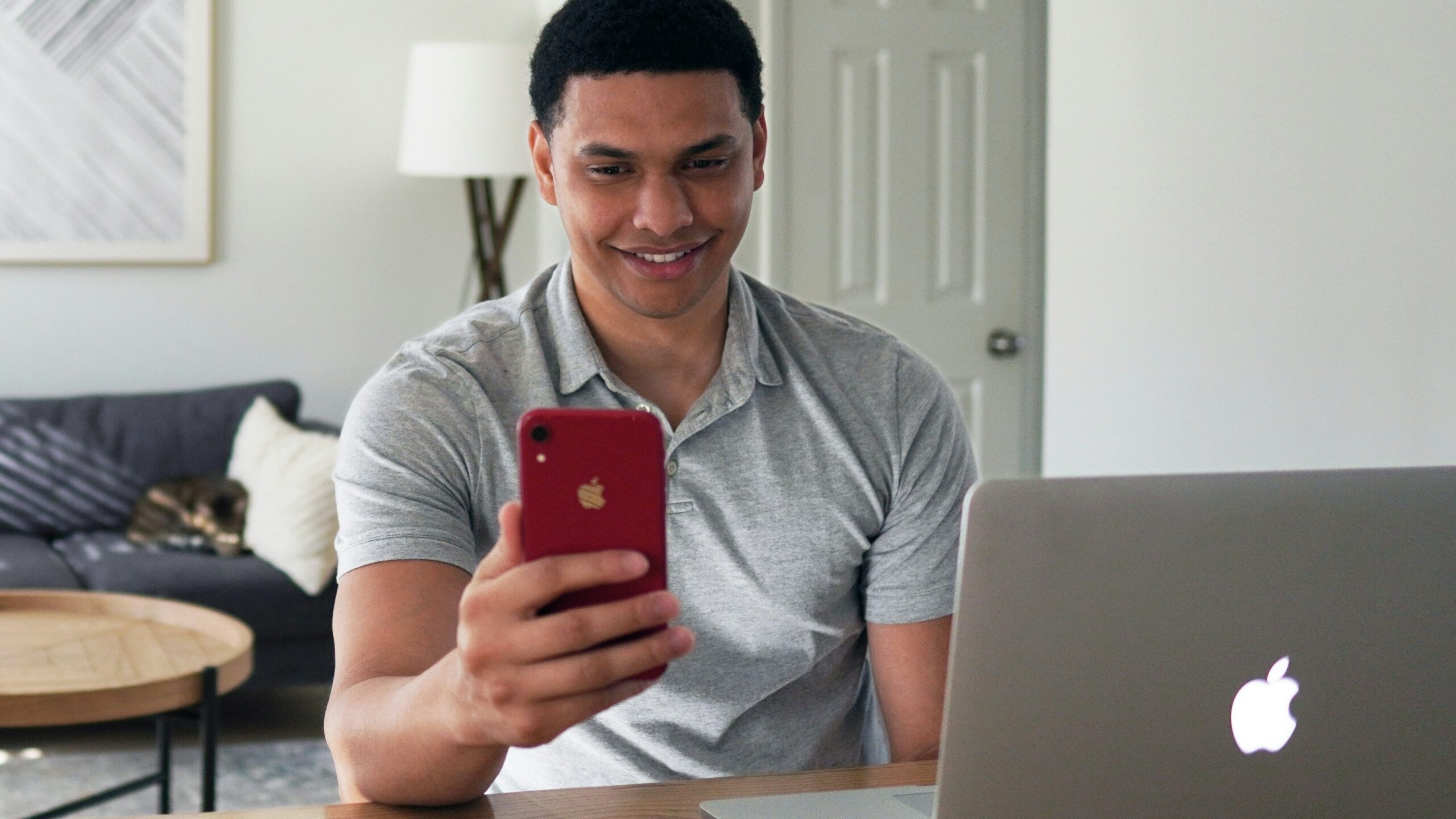 man in gray crew neck t-shirt holding red iphone case