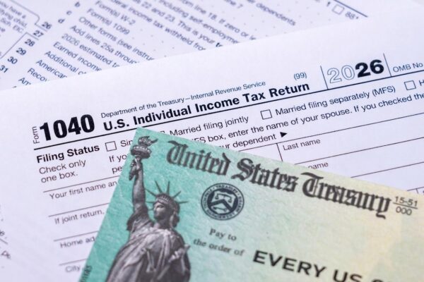 US Treasury stimulus check laying on a form 1040 tax return for 2020 to illustrate questions about qualification for payment