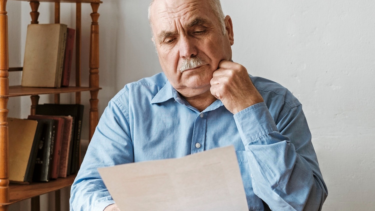 Thoughtful old man reading a paper document