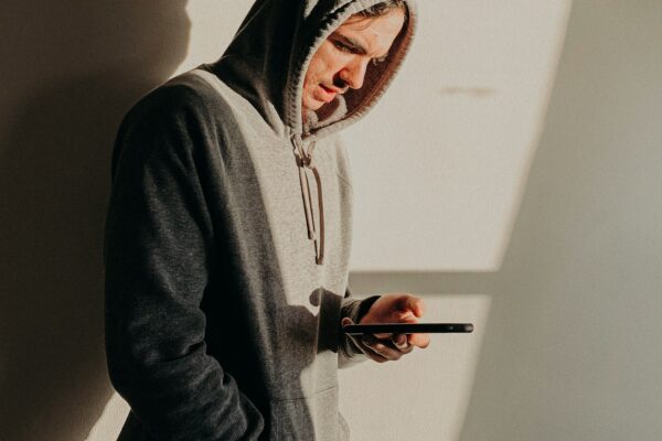 man in gray hoodie holding red and black toy gun