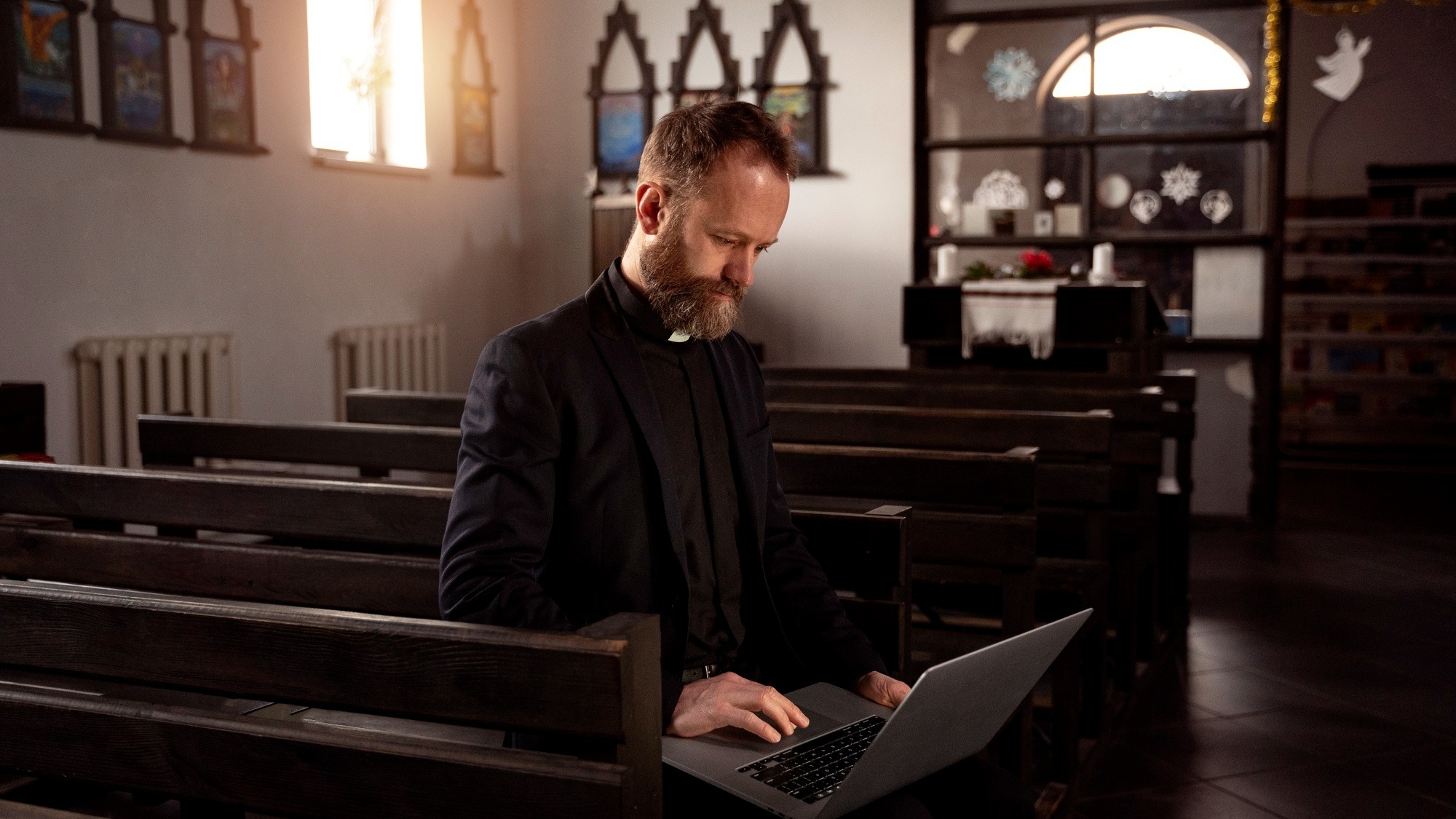 Close up on priest using laptop