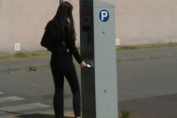 Dziewczyna korzystająca z parkometru z panelem fotowoltaicznym w Tomaszowie Mazowieckim