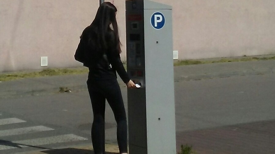Dziewczyna korzystająca z parkometru z panelem fotowoltaicznym w Tomaszowie Mazowieckim