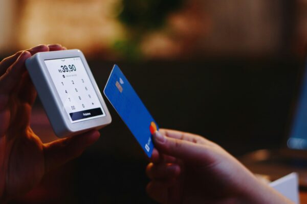 a person holding a credit card and a cell phone