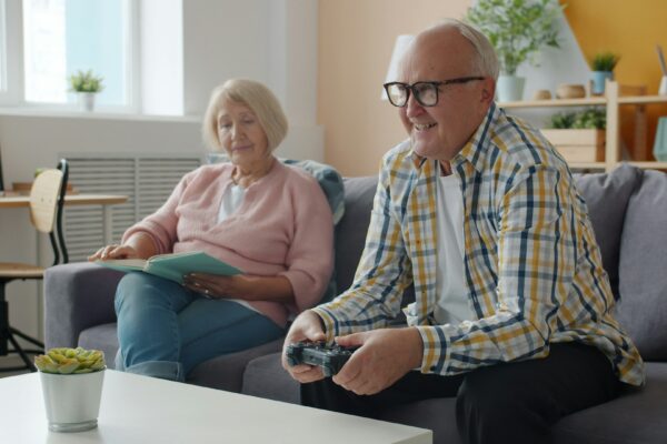 Elderly couple playing video games on the couch