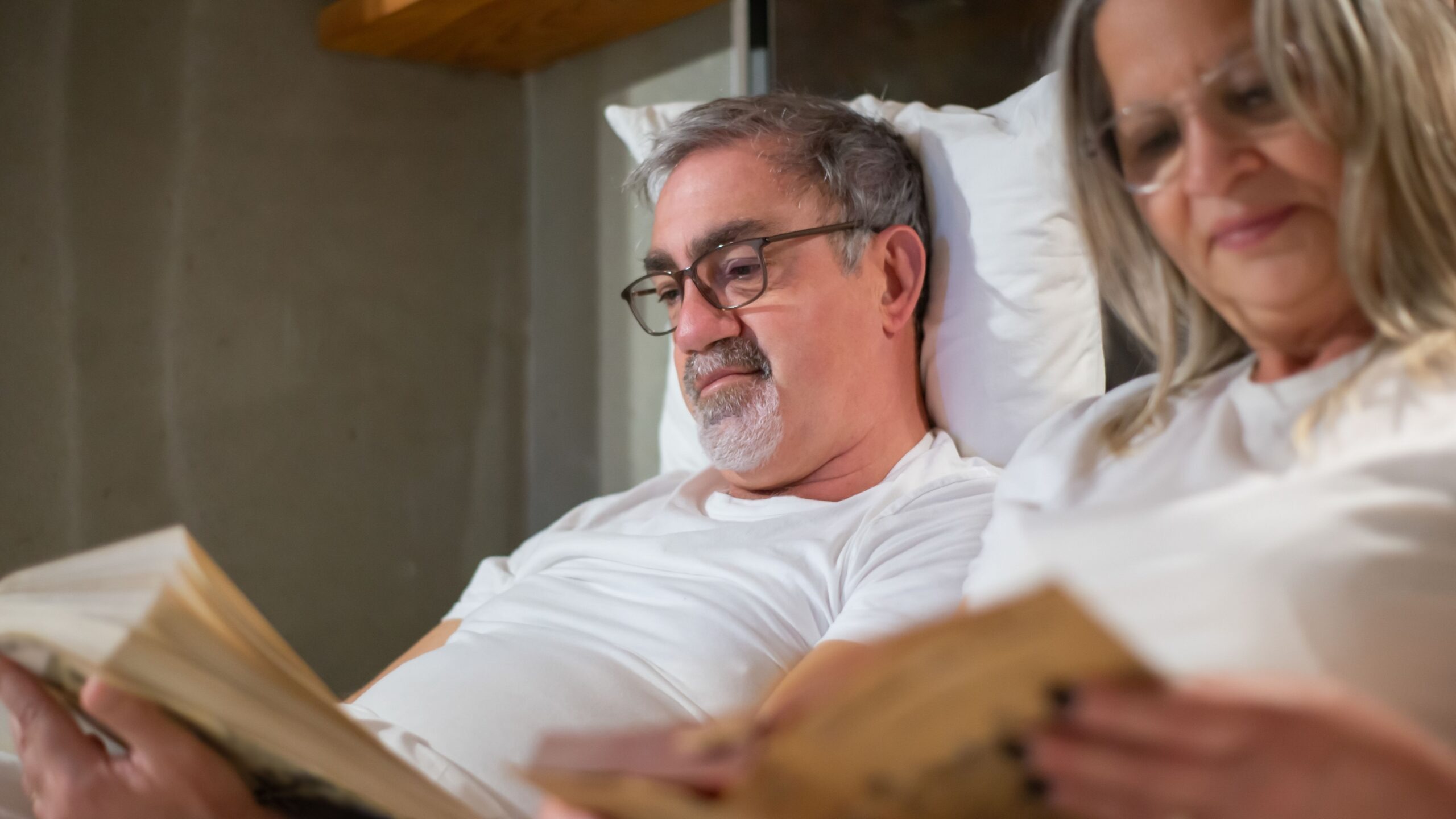 Elderly couple enjoying leisure reading in a cozy indoor setting. Perfect portrayal of retirement lifestyle.