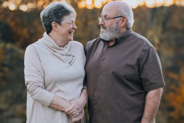 A man and woman standing next to each other in a field