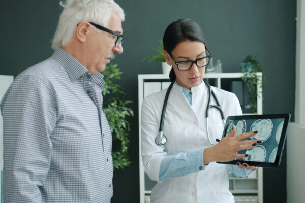 Doctor shows medical scan to elderly patient