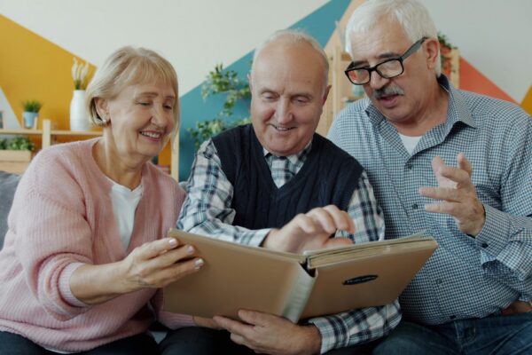 Three seniors looking at a photo album together