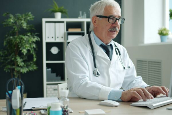 Doctor typing on computer in office