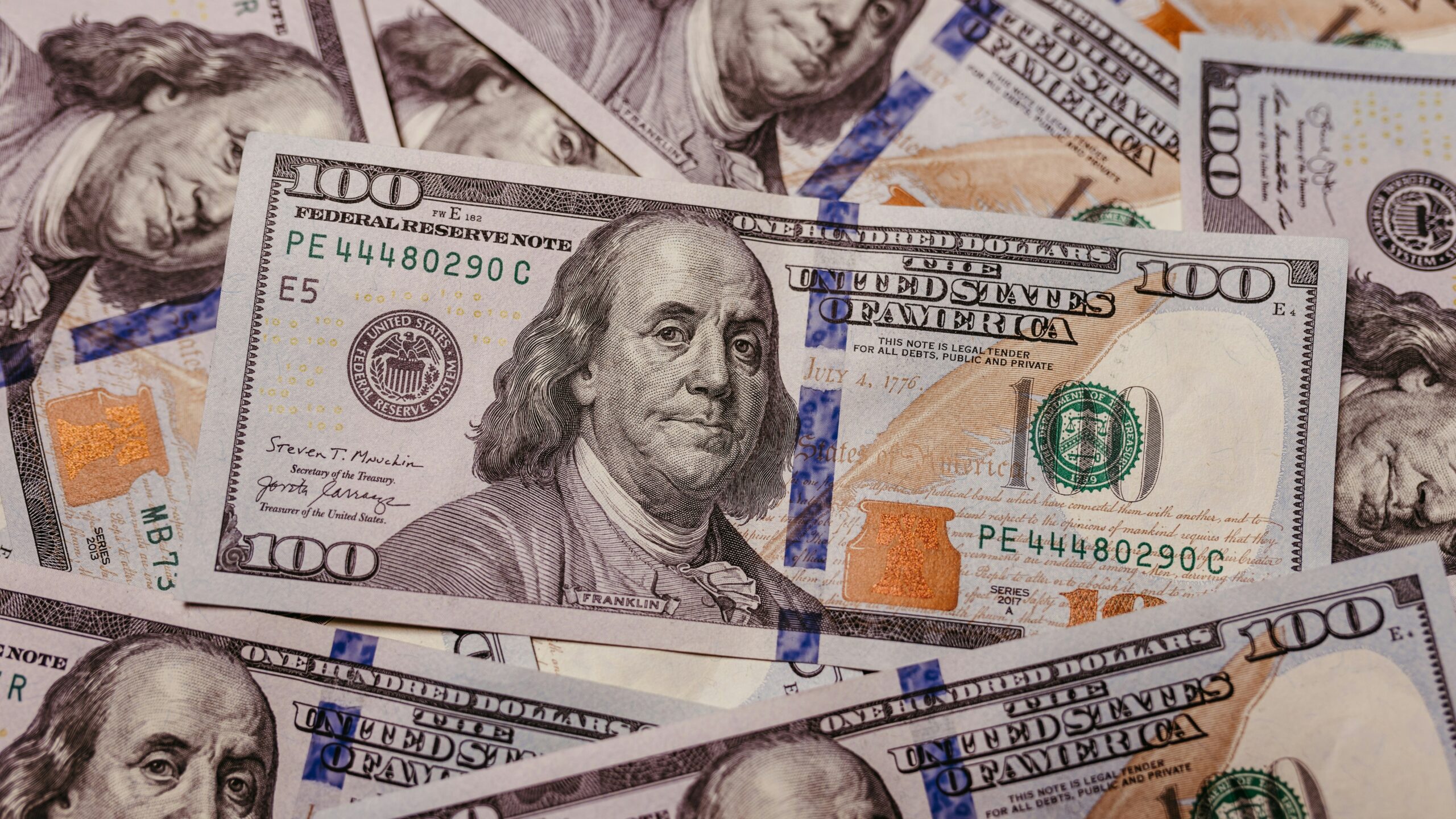 a pile of one hundred dollar bills