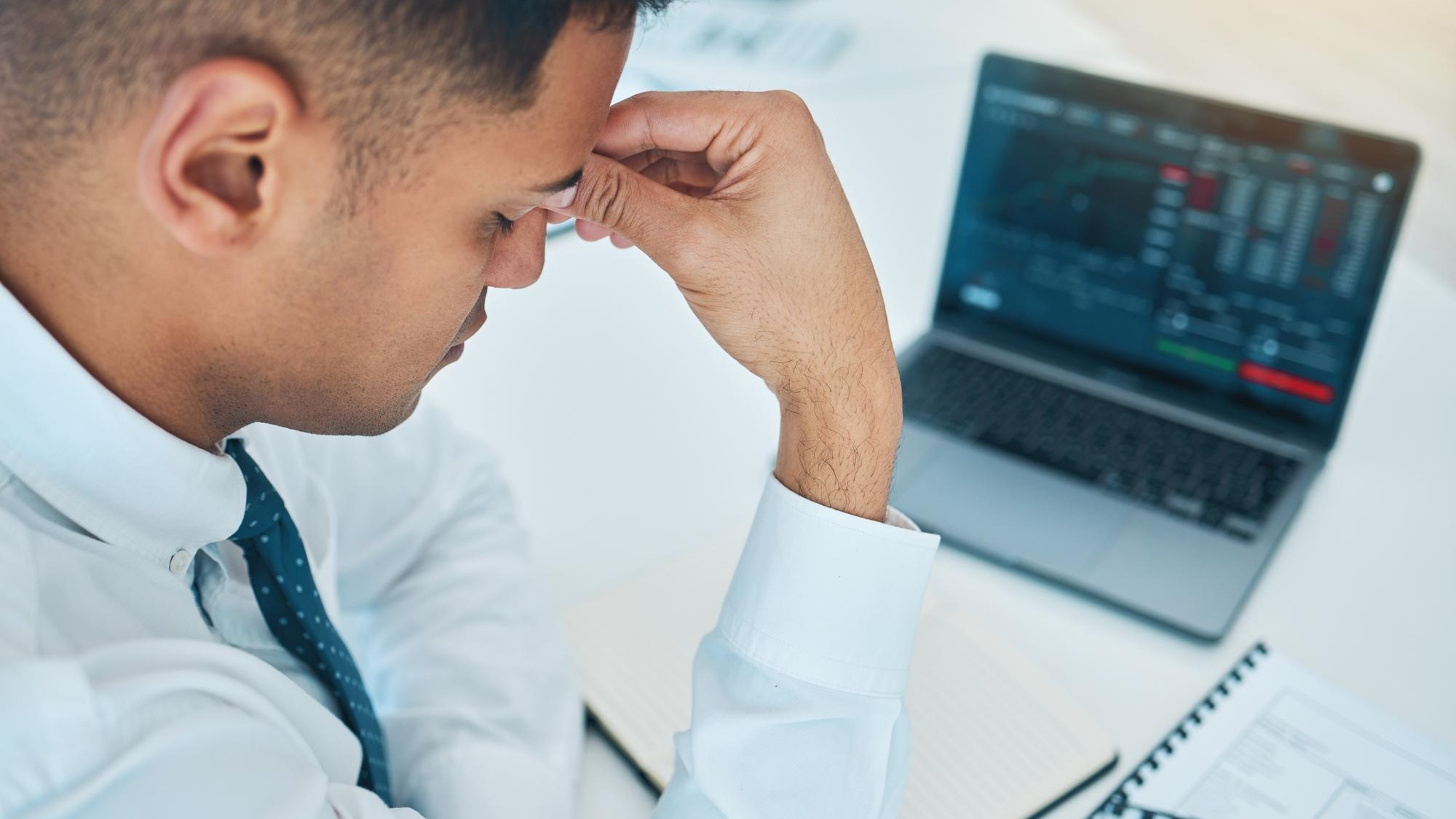 Business man headache and laptop of stock market crash bankruptcy and financial mistake error or wrong statistics Sad stress or fatigue trader on computer screen data or trading with depression