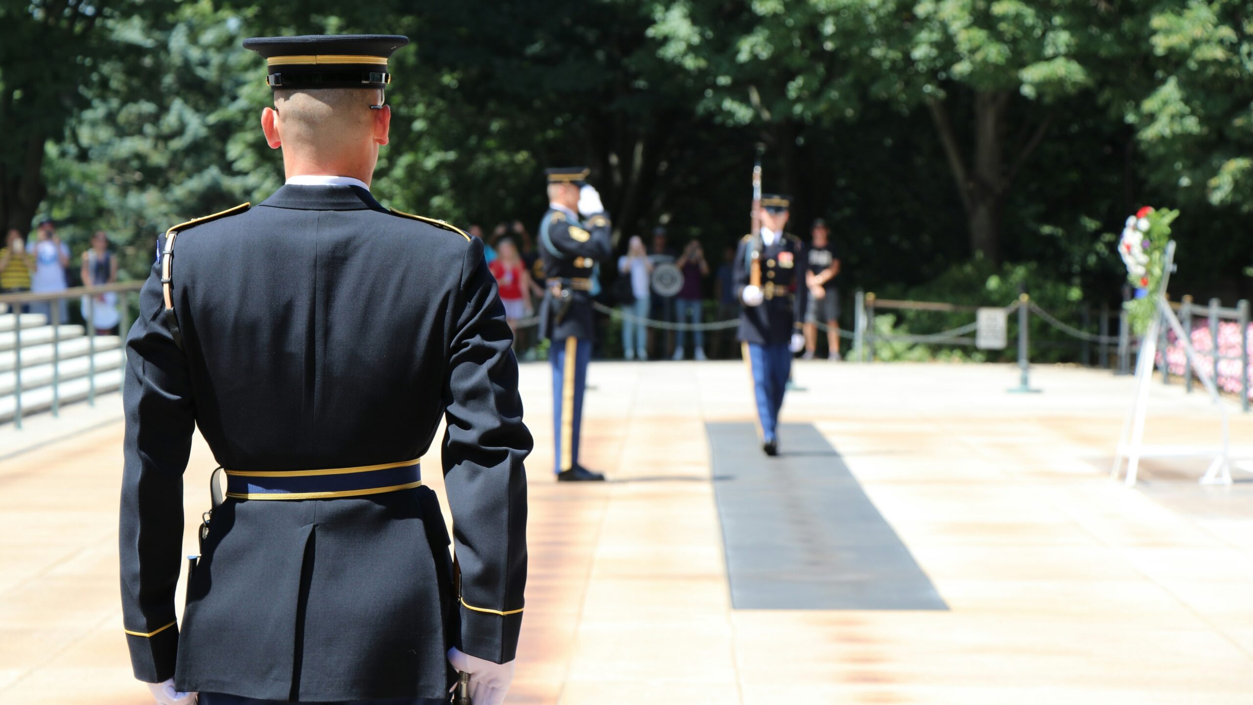 man in black uniform standing on gray concrete floor during daytime