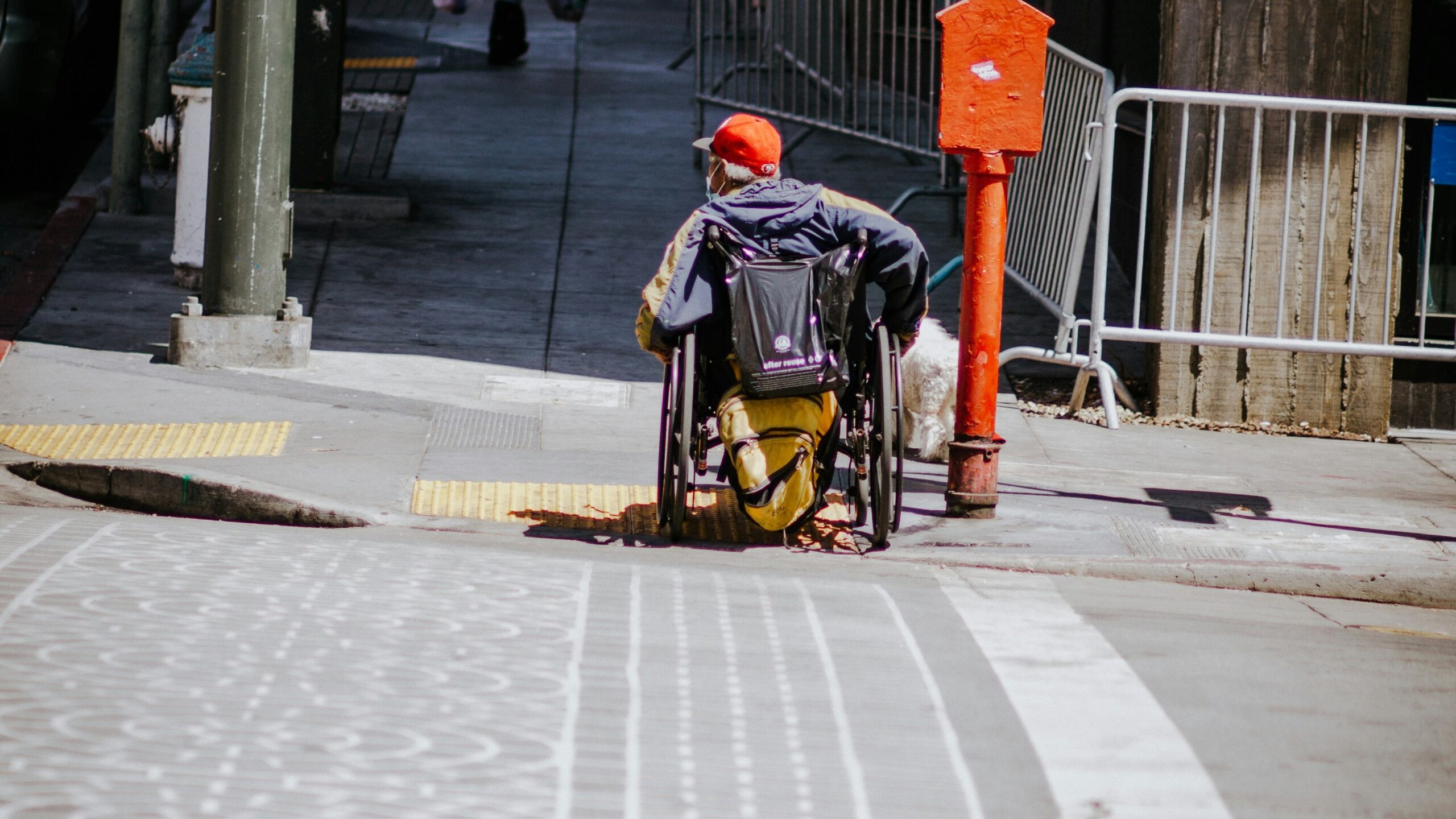 man in black jacket and black backpack walking on sidewalk during daytime
