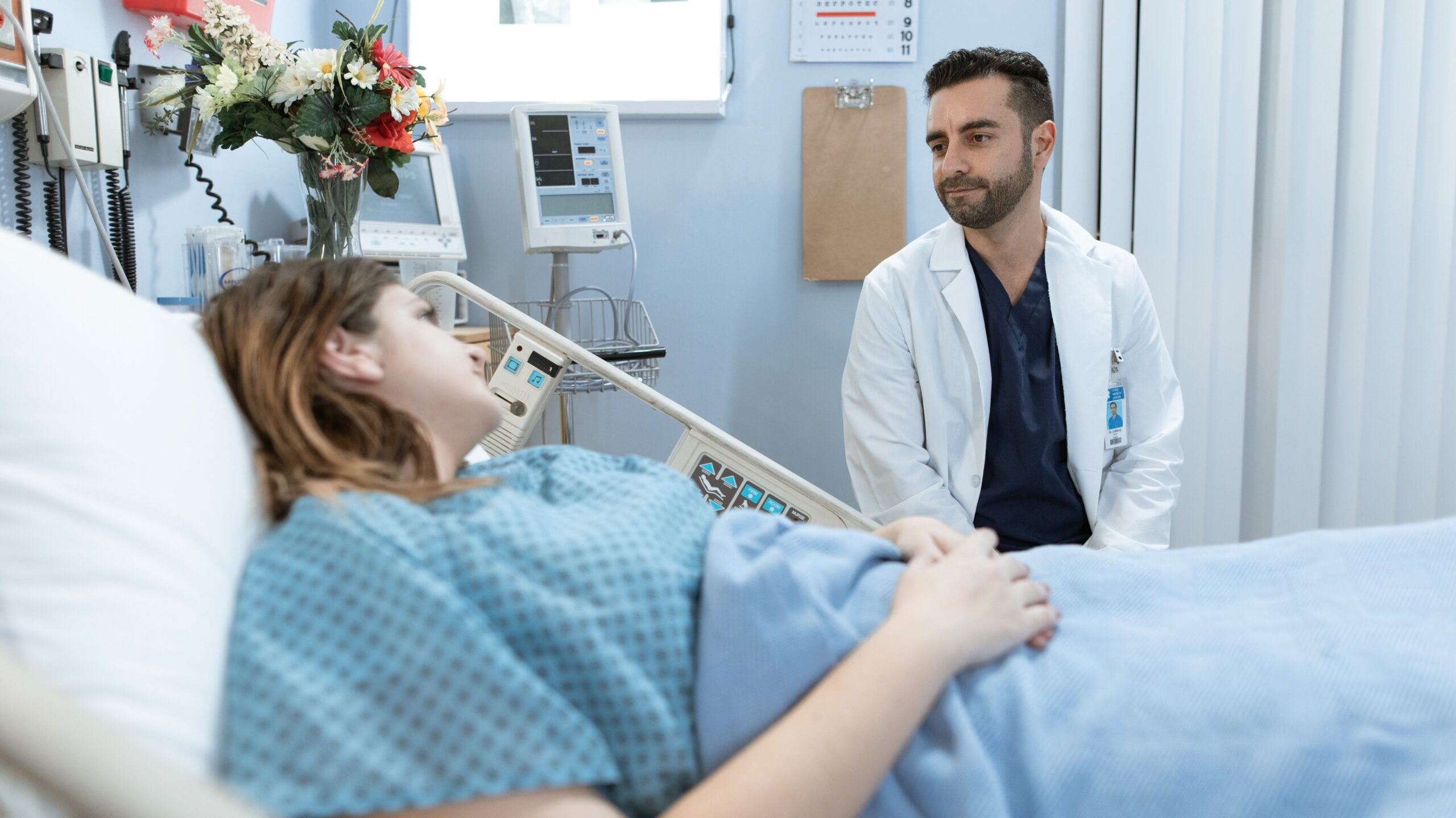 A doctor comforts a patient in a hospital room, emphasizing professional care.