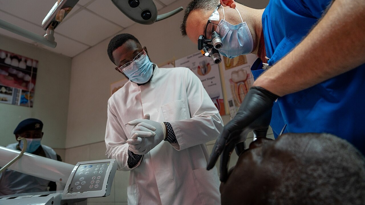 U.S. Army Maj. Bryant Farr, an endodontist assigned to Dental Health Activity Bavaria, examines the mouth of a patient during the medical readiness exercise (MEDREX) at the 37th Military Hospital in Accra, Ghana, May 19, 2025. Part of African Lion 2025 (AL25), this MEDREX is planned and executed by U.S. Army Southern European Task Force, Africa (SETAF-AF), and prepares U.S. military health professionals for the challenges of providing care outside of traditional clinical settings. By working alongside African partners, U.S. medical professionals refine their ability to deliver rapid, adaptable, and resource efficient medical care, directly increasing medical readiness for large scale combat operations. AL25, the largest annual military exercise in Africa, will take place from April 14 to May 23, 2025. Led by SETAF-AF, on behalf of U.S. Africa Command with over 10,000 troops from more than 50 nations, including seven NATO allies, across Ghana, Morocco, Senegal, and Tunisia. The exercise aims to bolster military readiness, enhance lethality, and foster stronger partnerships, ultimately improving joint capabilities in complex multi-domain environments to enable participating forces to deploy, fight, and win. (U.S. Army photo by 1st Lt. Katherine Sibilla)