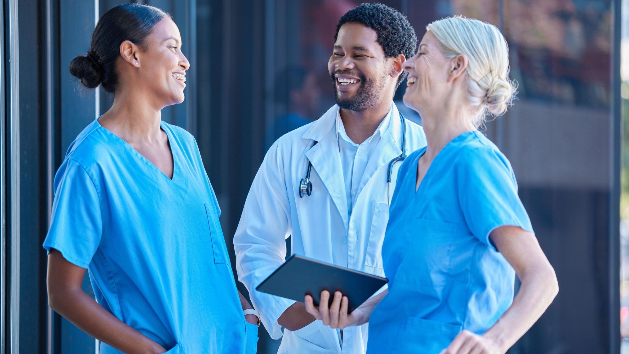 Diversity teamwork and healthcare a team of doctors talking and laughing outside a hospital A happy black doctor and women nurses having a conversation A group of medical employees during a break
