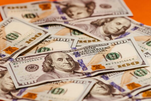 a pile of twenty dollar bills sitting on top of an orange table