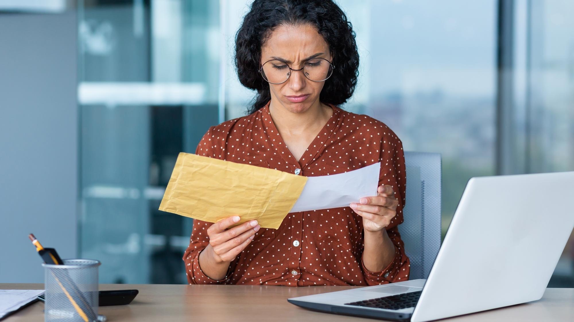 Dissatisfied and upset businesswoman received letter in envelope depressed latin american