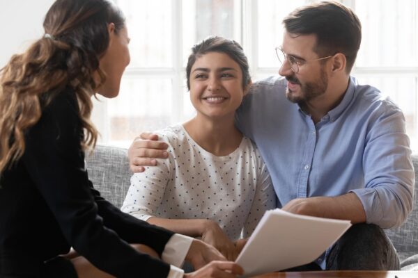 Financial advisor consulting diverse young family couple about deal