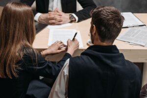A lawyer discusses legal documents with clients in an office setting.